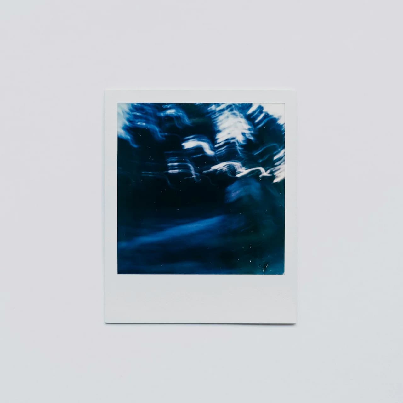 Stos kwadratowych wydrukowanych zdjęć podobnych do polaroida na drewnianym tle