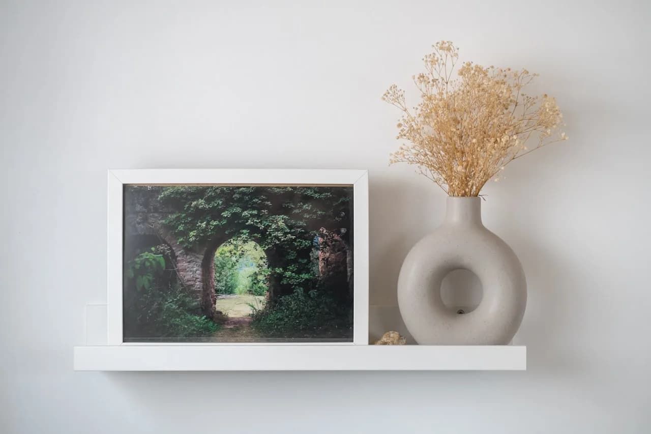 Kilka kwadratowych zdjęć 15 × 15 cm na białej ścianie w symetrycznym układzie