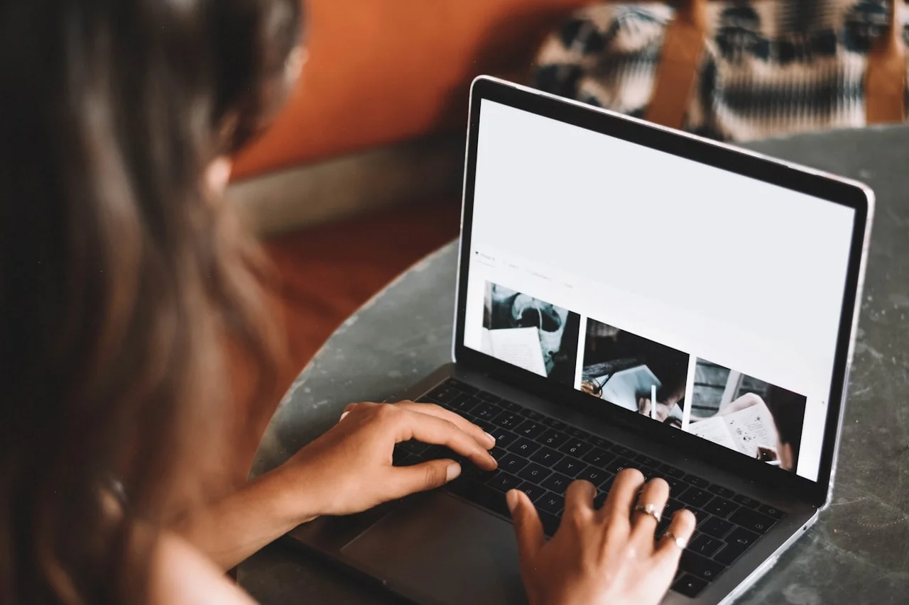 Osoba przegląda zdjęcia na laptopie przy świetle dziennym
